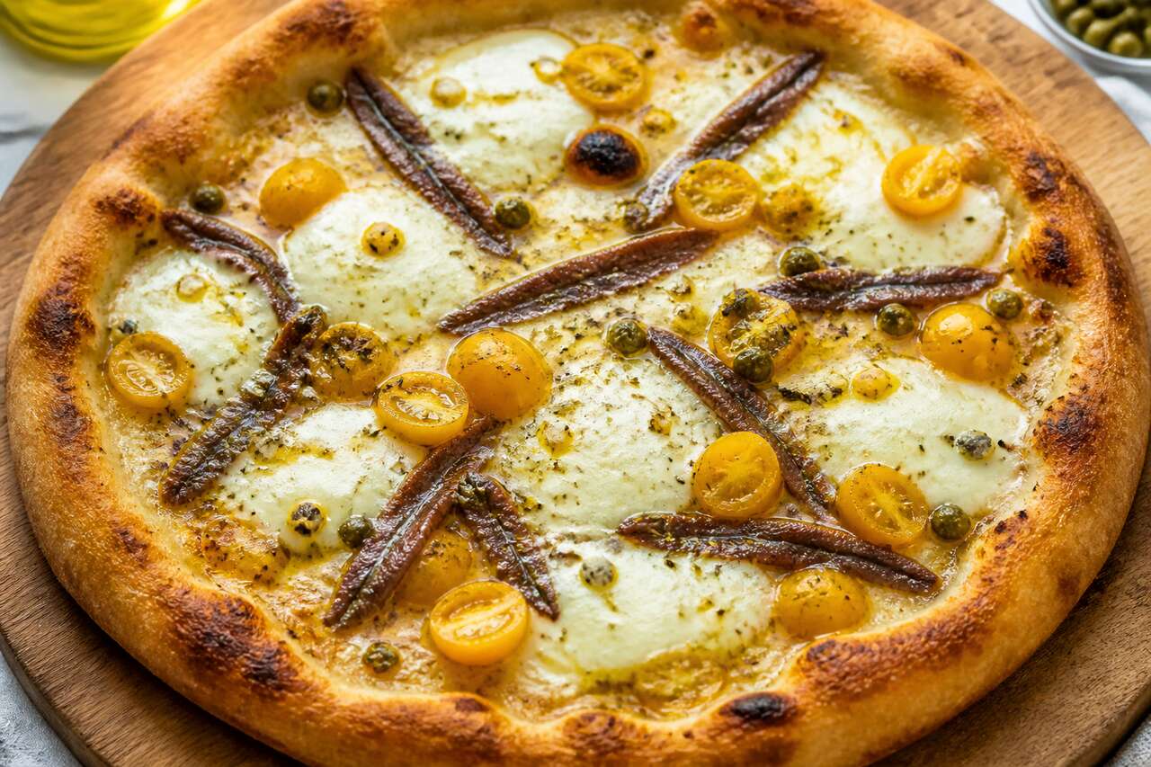 Recette de pizza aux tomates cerises jaunes, anchois et câpres